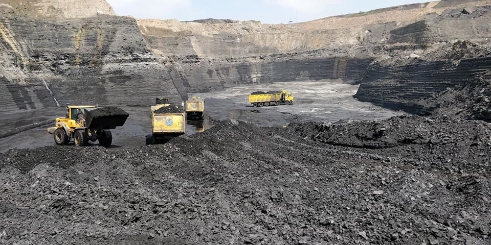 Bagger und Laster beim Kohleabbau in einer indischen Mine