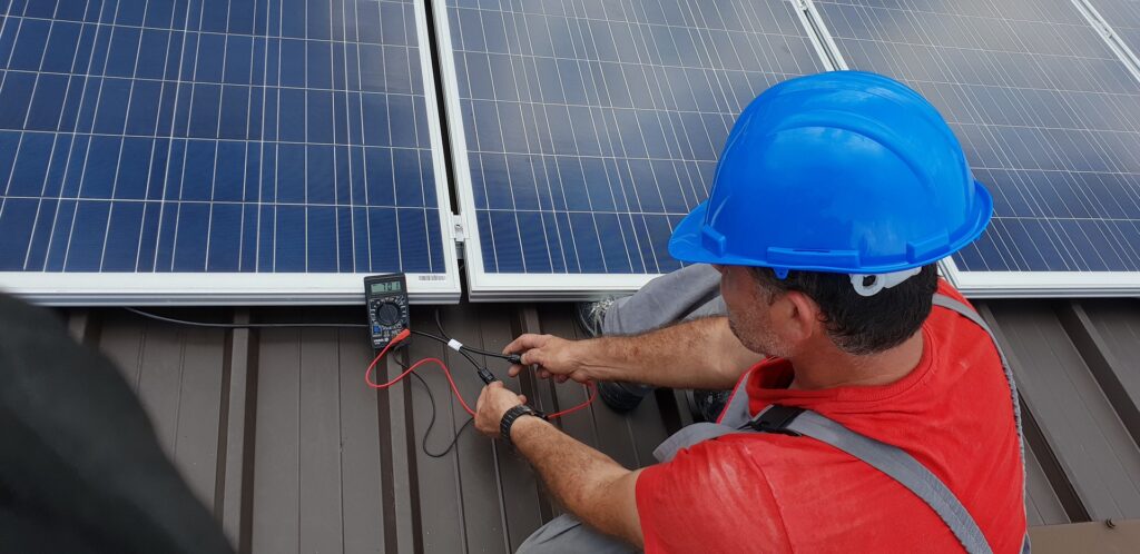 Ein Techniker prüft die Spannung an einem neu installierten Solarmodul