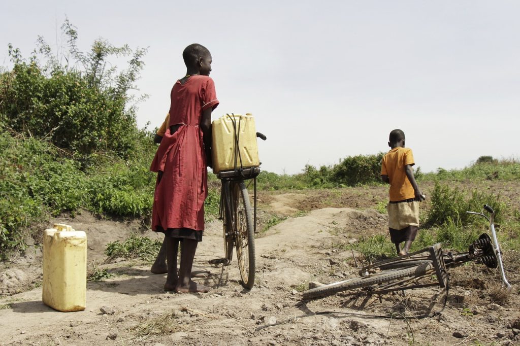 Kinder in Uganda holen Wasser in Kanistern per Fahrrad von weit her