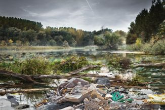 Mit Plastikmüll verschandelte Fluss-Landschaft - die Plastikflut ist ein globales Umweltproblem