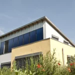 Einfamilienhaus mit vertikalen Sonnenkollektoren an der Wand: Neue Rolle für die Solarthermie bei der Heizungswende