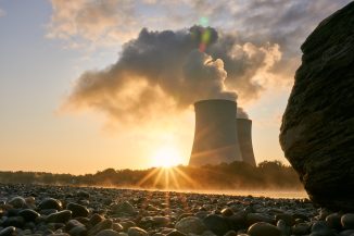 Kühltürme eines Atomkraftwerks, Fluss mit Niedrigwasser: mehr Unternehmen spüren die Klimakrise